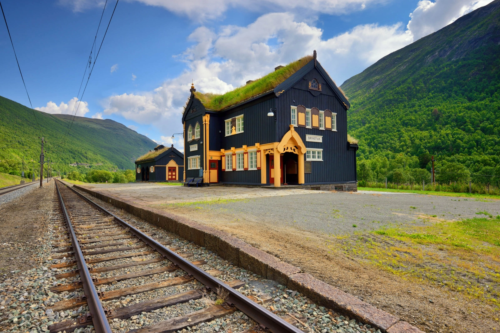 Tåget passerar vackra, äldre stationsbyggnader