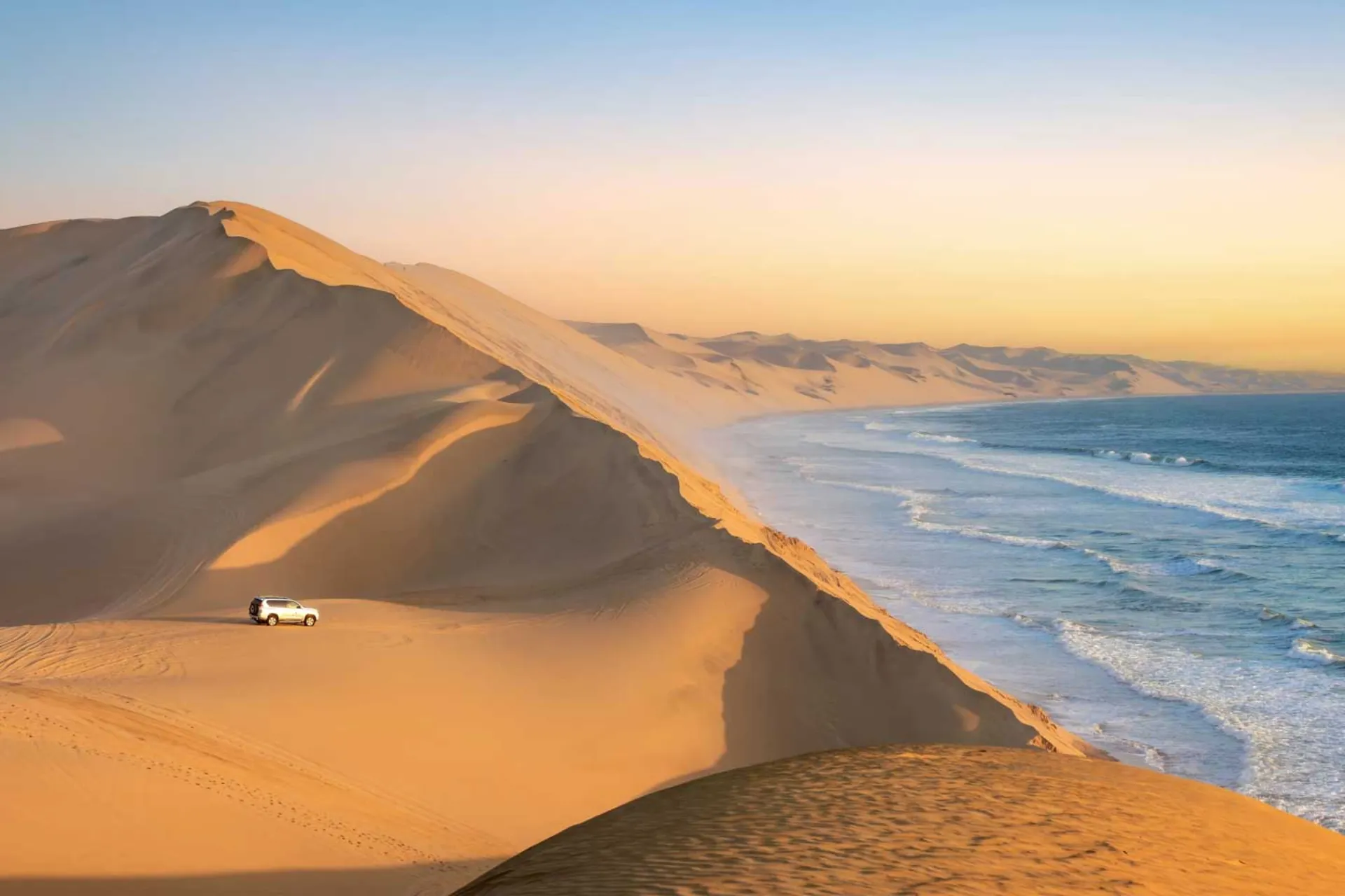 Sandwich Harbour i Namibia, där de höga sanddynerna sluttar direkt ner i havet
