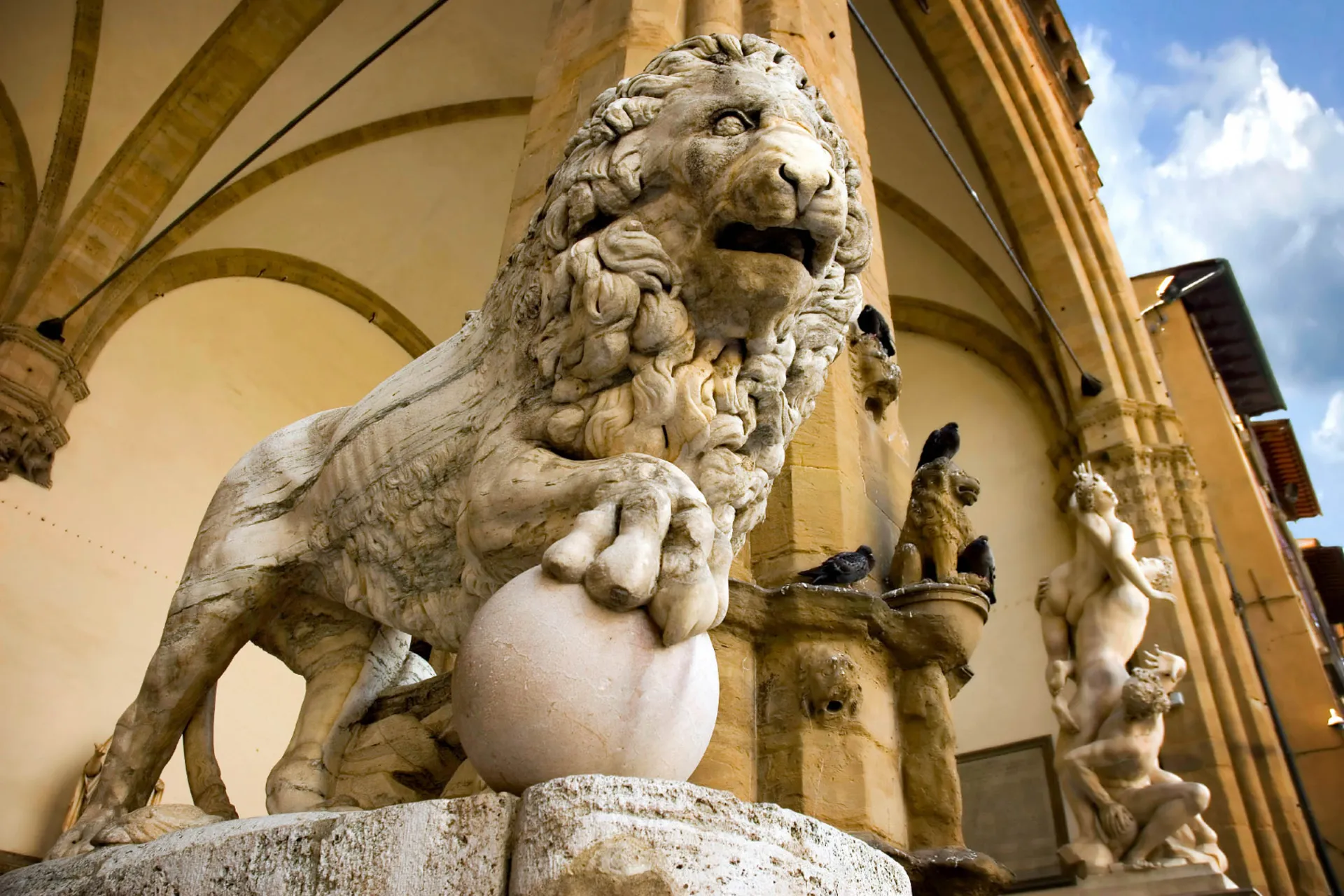 Lejonsskulptur i marmor omgiven av konstnärliga detaljer Lejonsskulptur i marmor omgiven av konstnärliga detaljer