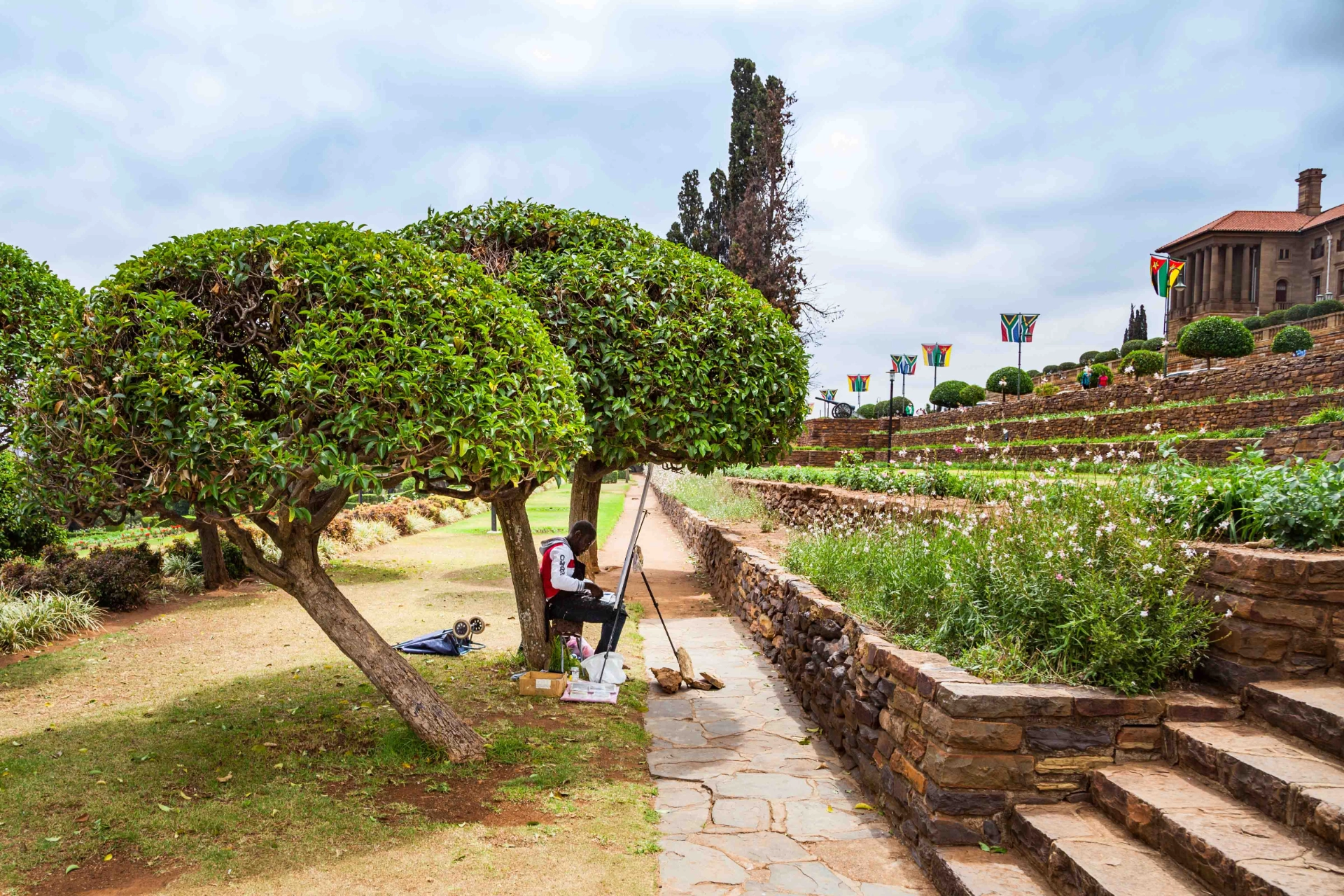 Konstnär i parken framför regeringsbyggnaden i Pretoria