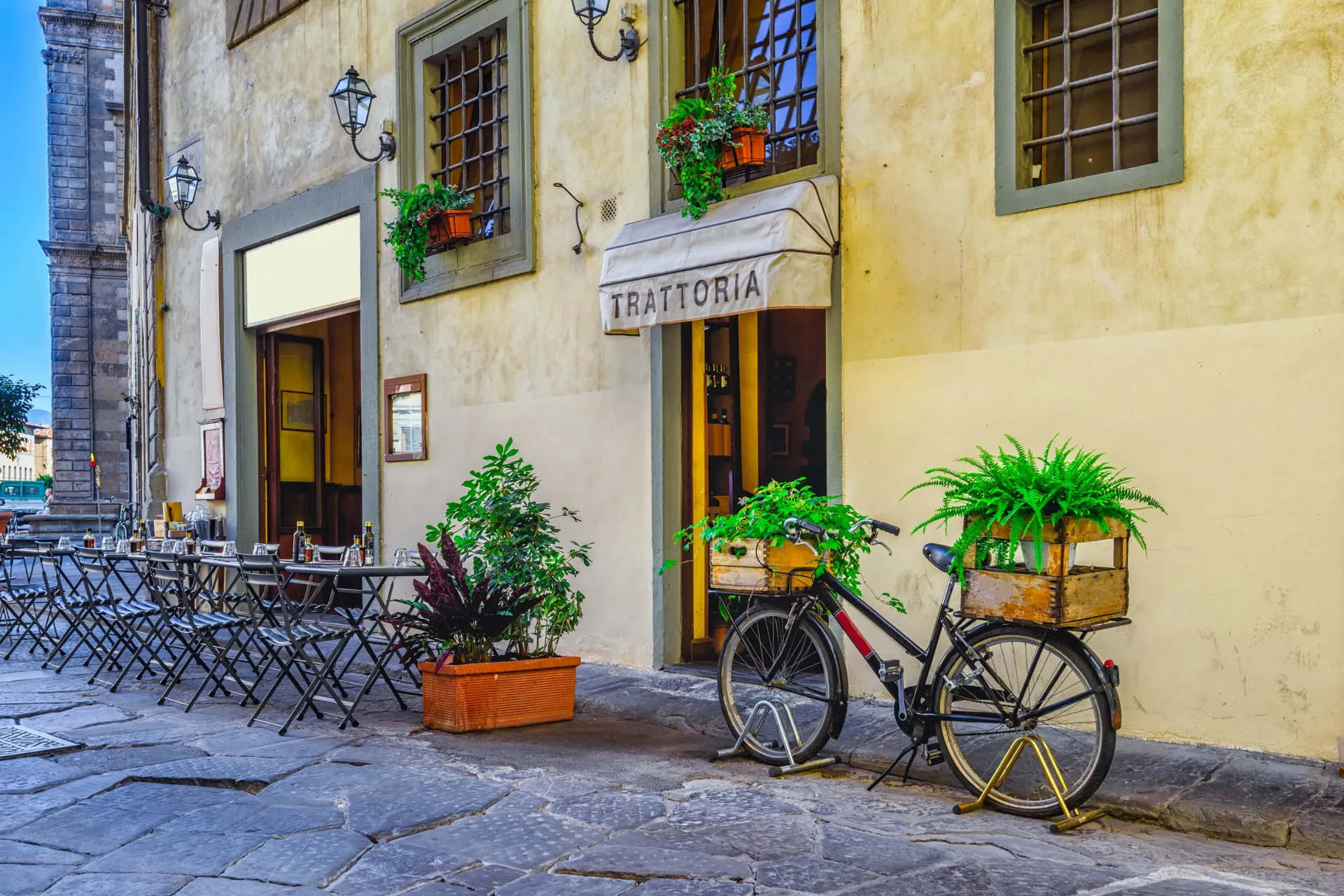 Trattoria med uteservering och cykel med blommor Trattoria med uteservering och cykel med blommor