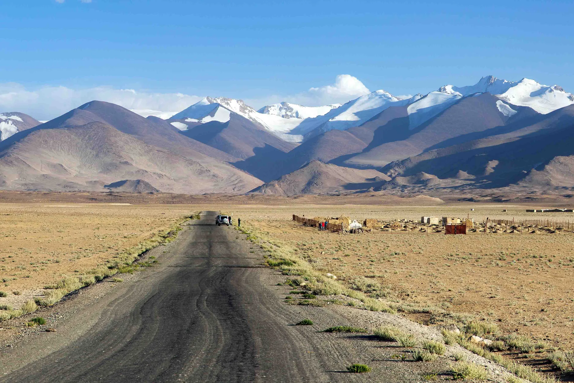 En öde och karg sträcka längs den berömda Pamir Highway med Tadzjikistans snötäckta bergstoppar i bakgrunden
