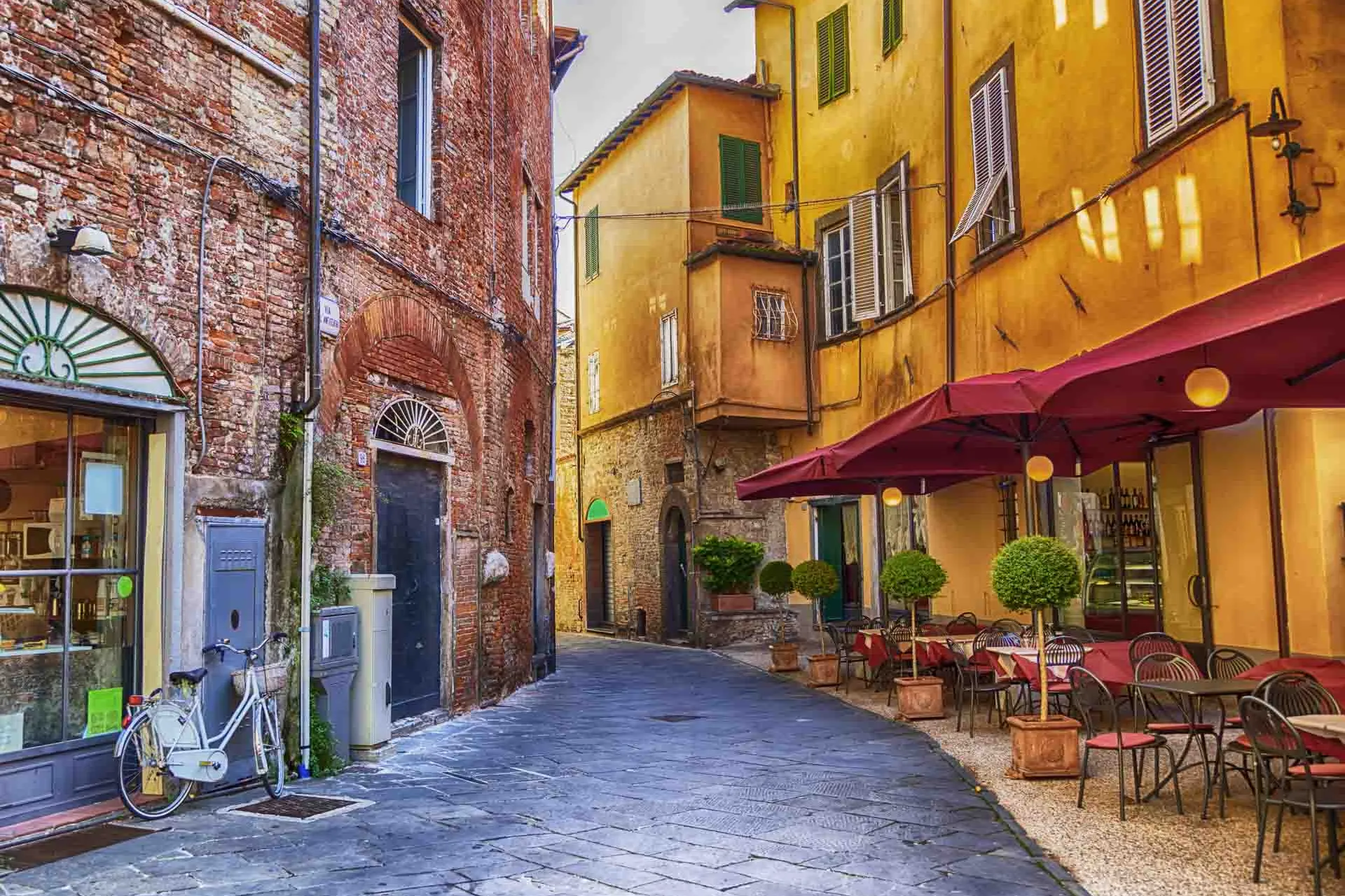 Mysig gata i Lucca med café och färgglada hus Mysig gata i Lucca med café och färgglada hus