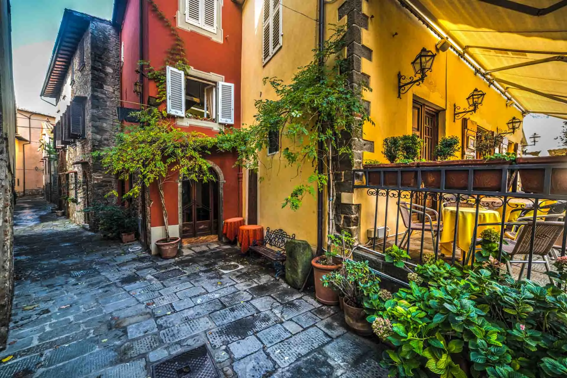 Mysig gränd i Montecatini Alto med färgglada hus och växter Mysig gränd i Montecatini Alto med färgglada hus och växter