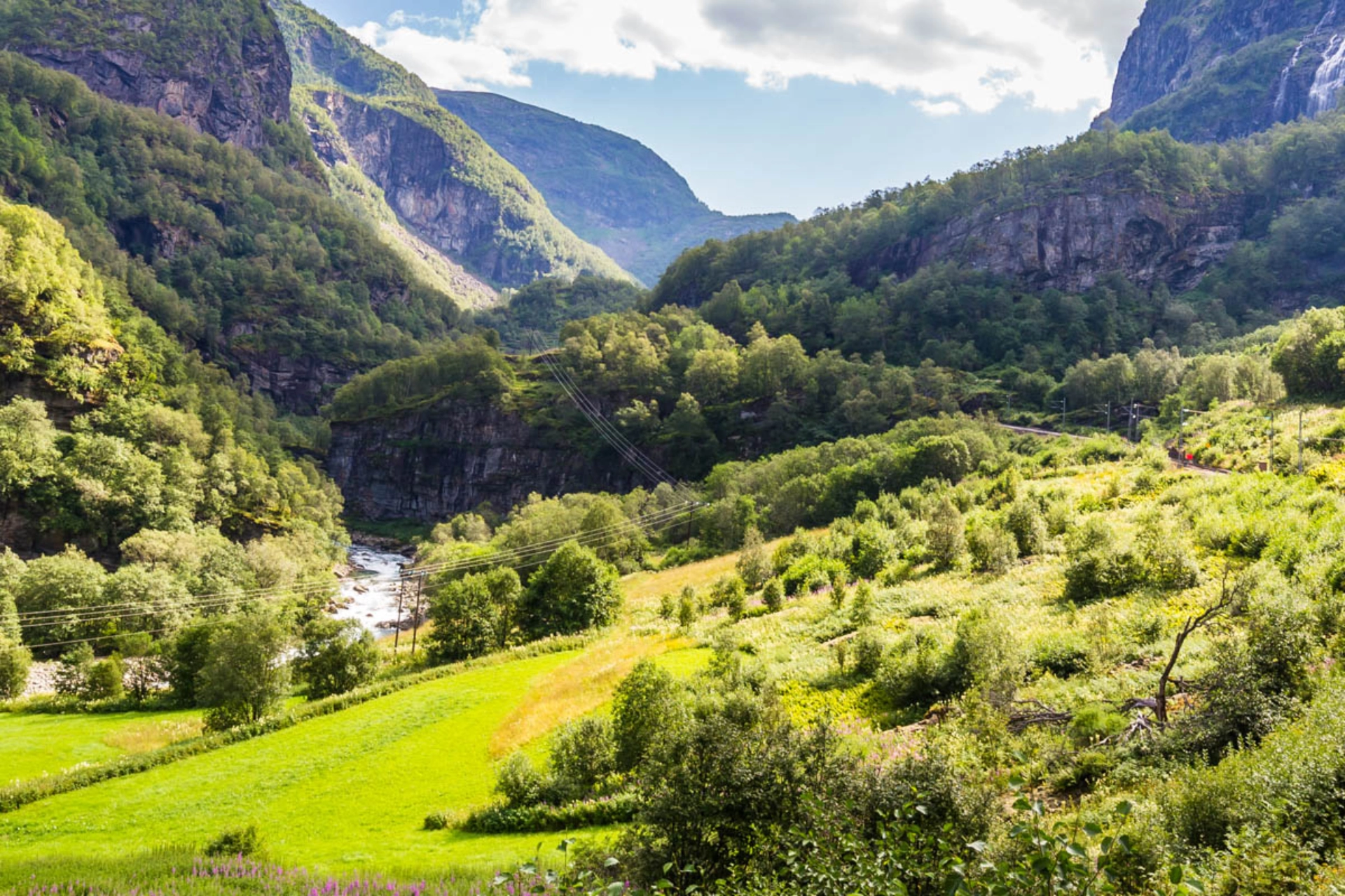Tåget går längs brusande älvar, fjäll och frodiga dalar