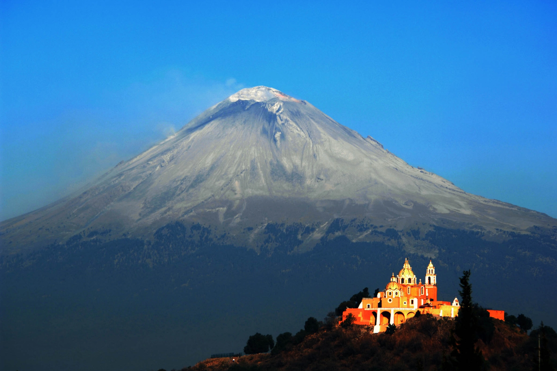 Iglesia de Nuestra Señora de los Remedios med den aktiva vulkanen Popocatépetl i bakgrunden