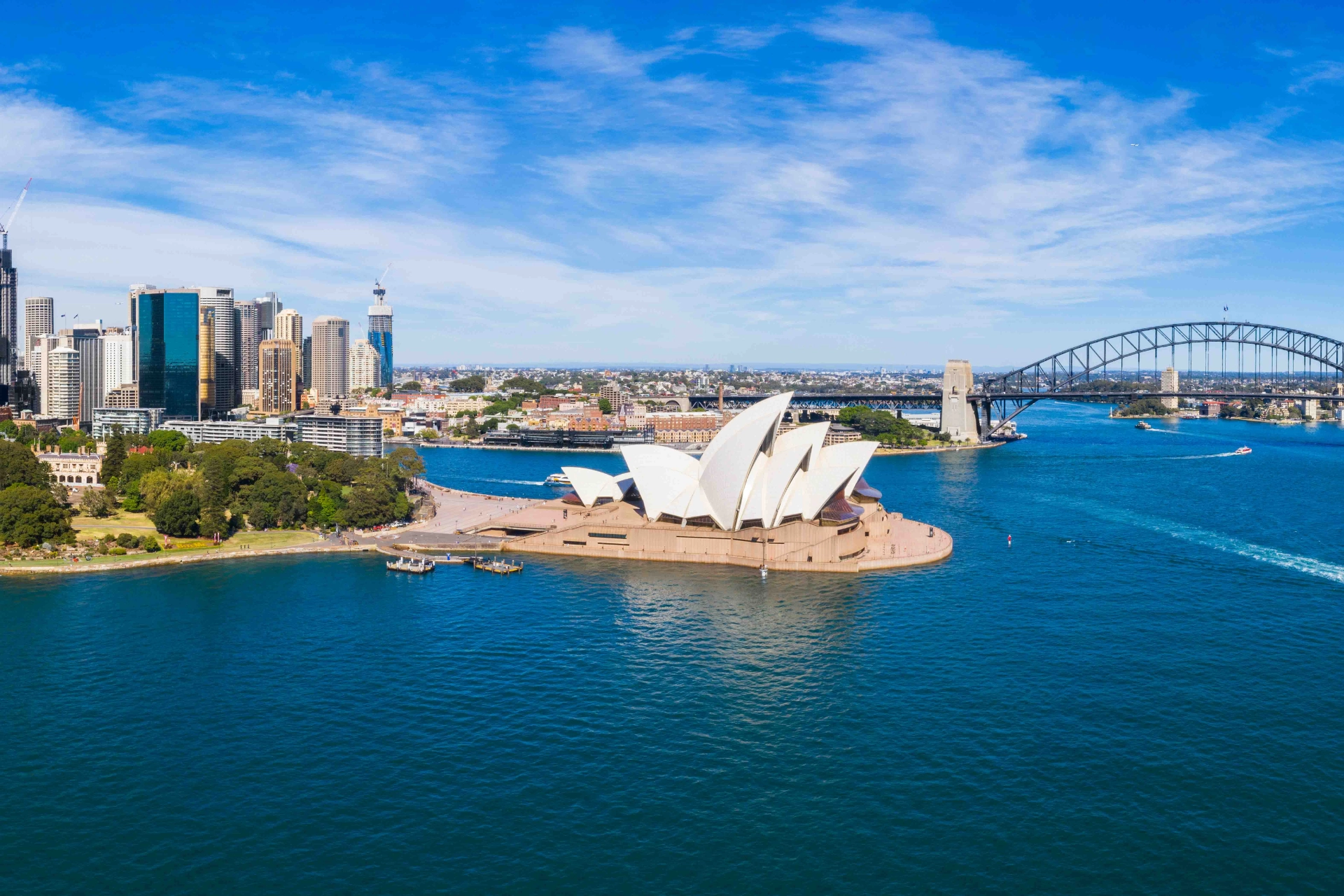 Flygbild över Sydney med hamnbron, Operan och stadens skyline