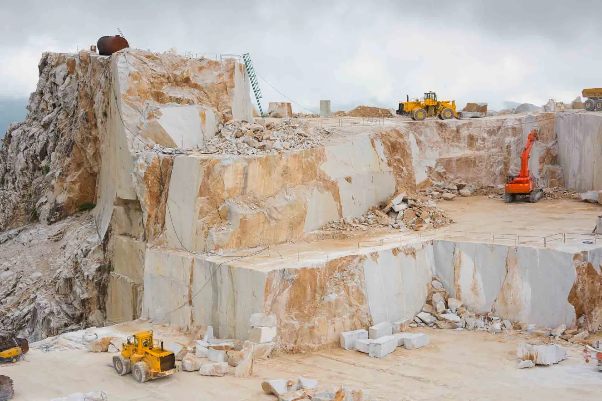 Carrara-marmorbrott med stora stenblock och arbetsmaskiner Carrara-marmorbrott med stora stenblock och arbetsmaskiner