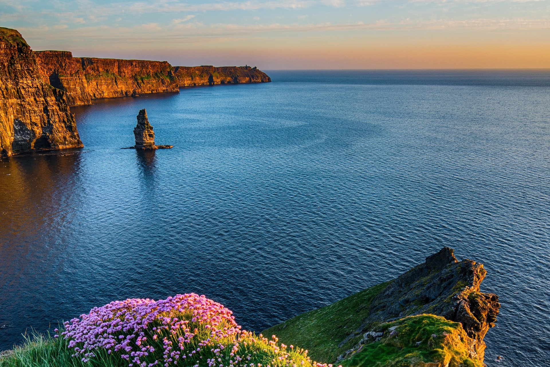Cliffs of Moher i gyllene kvällsljus. Klippspiran i vattnet heter Branaunmore