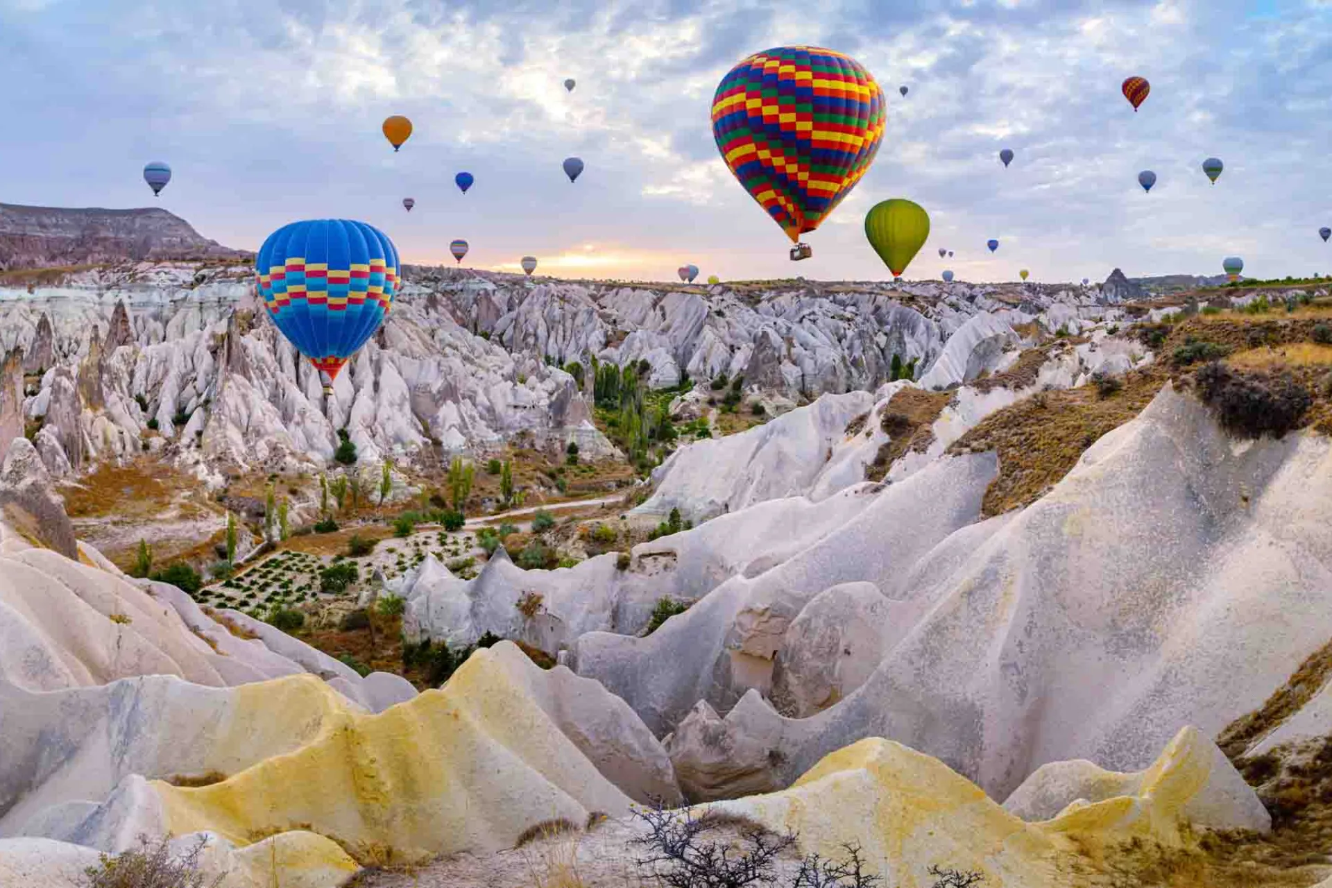 Varmluftsballonger svävar över de unika klippformationerna i Kappadokien Varmluftsballonger svävar över de unika klippformationerna i Kappadokien