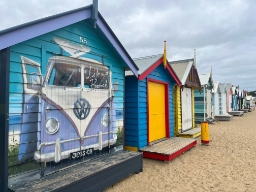 Färgglada strandstugor längs Brighton Beach