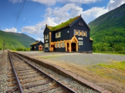 Tåget passerar vackra, äldre stationsbyggnader