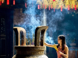 Kvinna med rökelsepinnar i Thien Hau-templet