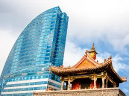 Buddhistiskt tempel och Blue Sky Tower sida vid sida i Ulan Bator, Mongoliet