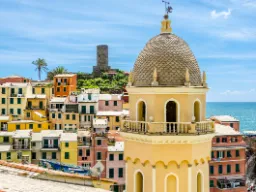 Kyrktorn i Vernazza med färgglada hus och havsutsikt Kyrktorn i Vernazza med färgglada hus och havsutsikt