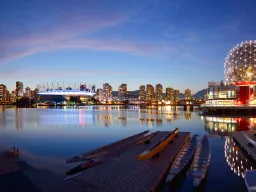 Kvällsljus över False Creek i Vancouver med skyline, BC Place och det upplysta Science World speglat i det stilla vattnet
