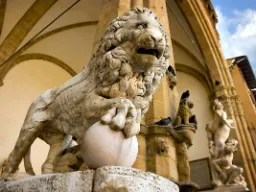 Lejonsskulptur i marmor omgiven av konstnärliga detaljer Lejonsskulptur i marmor omgiven av konstnärliga detaljer