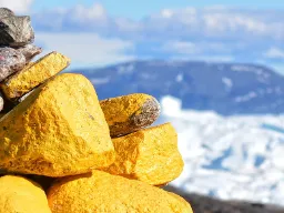 En vardestack med gula och grå stenar med utsikt över isfjorden En vardestack med gula och grå stenar med utsikt över isfjorden