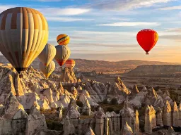 Luftballonger över Kappadokiens unika klippelandskap vid soluppgång Luftballonger över Kappadokiens unika klippelandskap vid soluppgång