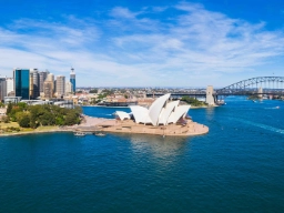 Flygbild över Sydney med hamnbron, Operan och stadens skyline