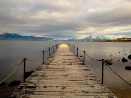 Från träbron vid Puerto Natales har man utsikt över Última Esperanza-fjorden och de omgivande bergen