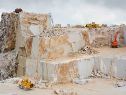 Carrara-marmorbrott med stora stenblock och arbetsmaskiner Carrara-marmorbrott med stora stenblock och arbetsmaskiner