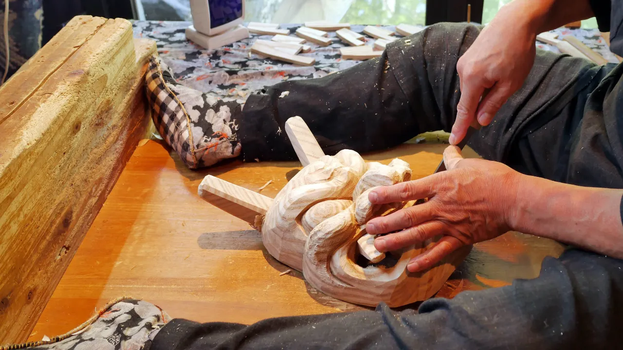 En japansk hantverkare snidar en traditionell trämask En japansk hantverkare snidar en traditionell trämask