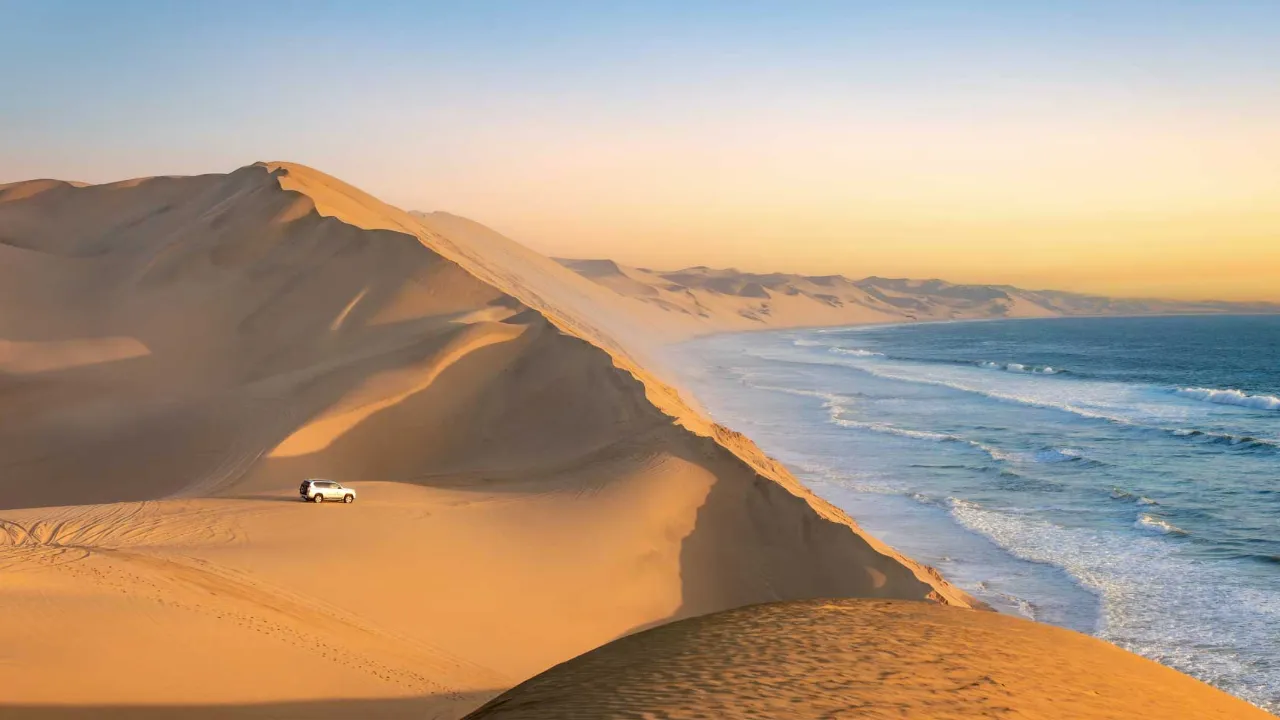Sandwich Harbour i Namibia, där de höga sanddynerna sluttar direkt ner i havet