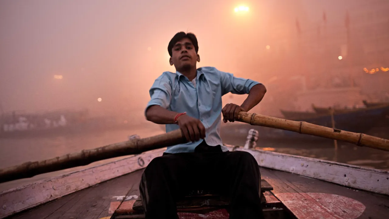 Båtman på Ganges i den tidiga morgondimman Båtman på Ganges i den tidiga morgondimman