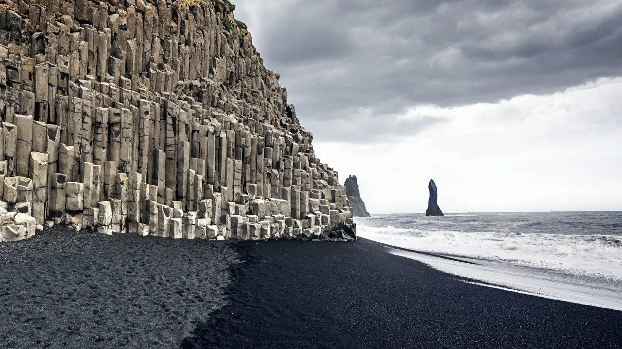 Den vackra svarta sandstranden Reynisfjara vid Dyrhólaey
