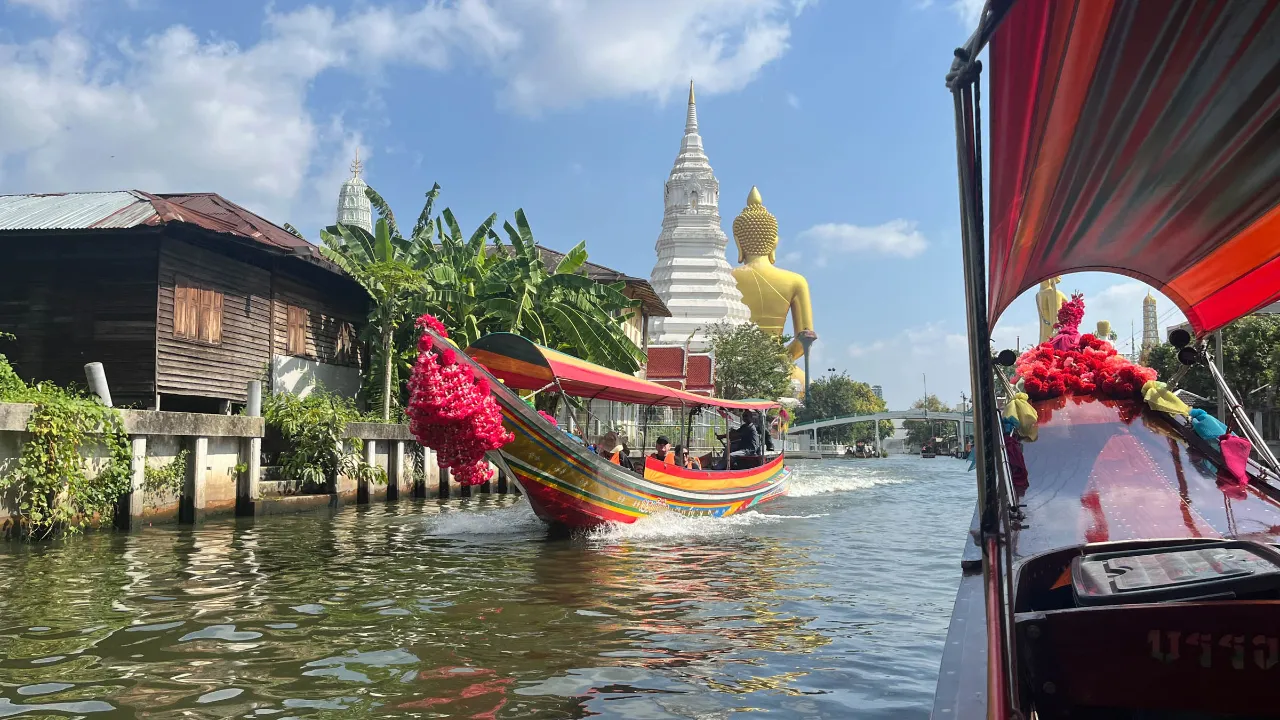 Kanaltur i Bangkok med stor gyllene Buddha-staty och en vit chedi (stupa) i bakgrunden Kanaltur i Bangkok med stor gyllene Buddha-staty och en vit chedi (stupa) i bakgrunden