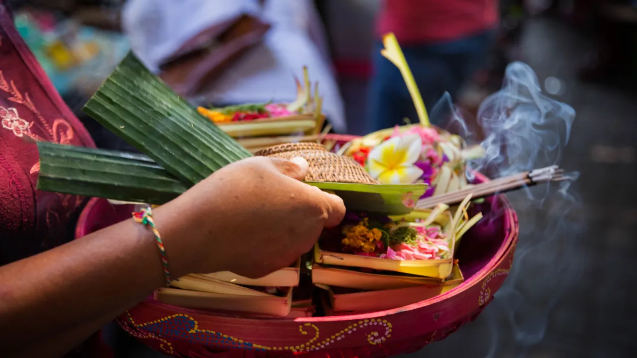 Balinesisk, hinduisk offergåva med blommor och rökelse