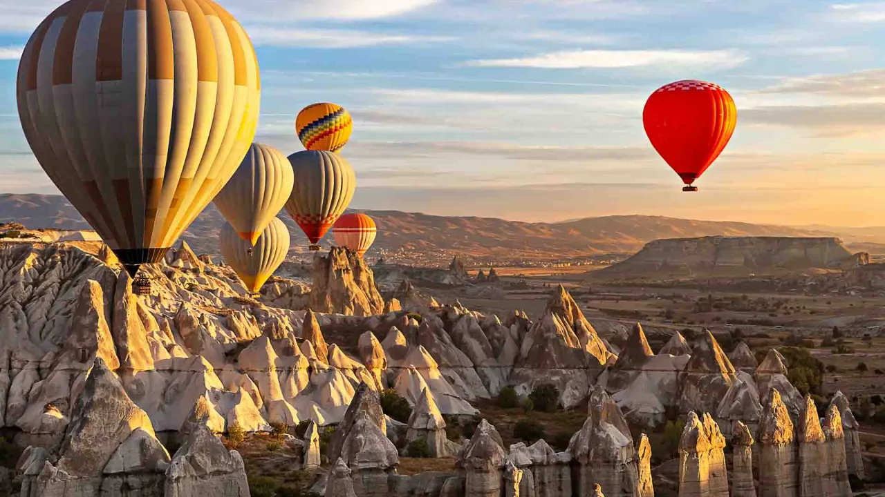 Luftballonger över Kappadokiens unika klippelandskap vid soluppgång