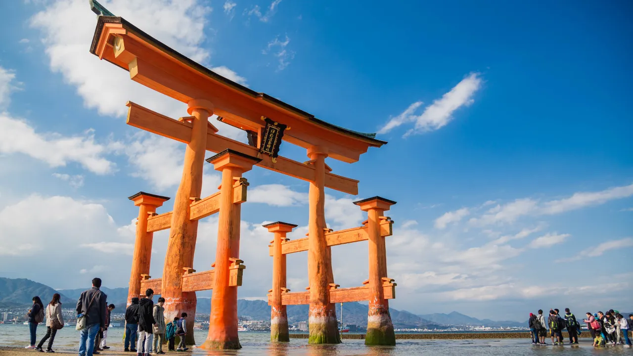 Den svävande röda torii-porten i vattnet vid ön Miya-jima Den svävande röda torii-porten i vattnet vid ön Miya-jima