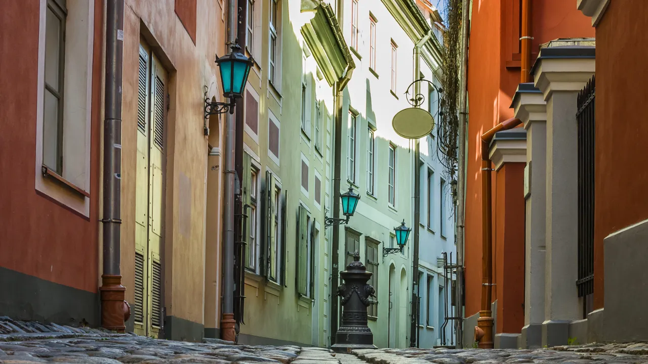 Smal, kullerstensbelagd gränd med färgglada fasader i gamla stan i Riga Smal, kullerstensbelagd gränd med färgglada fasader i gamla stan i Riga