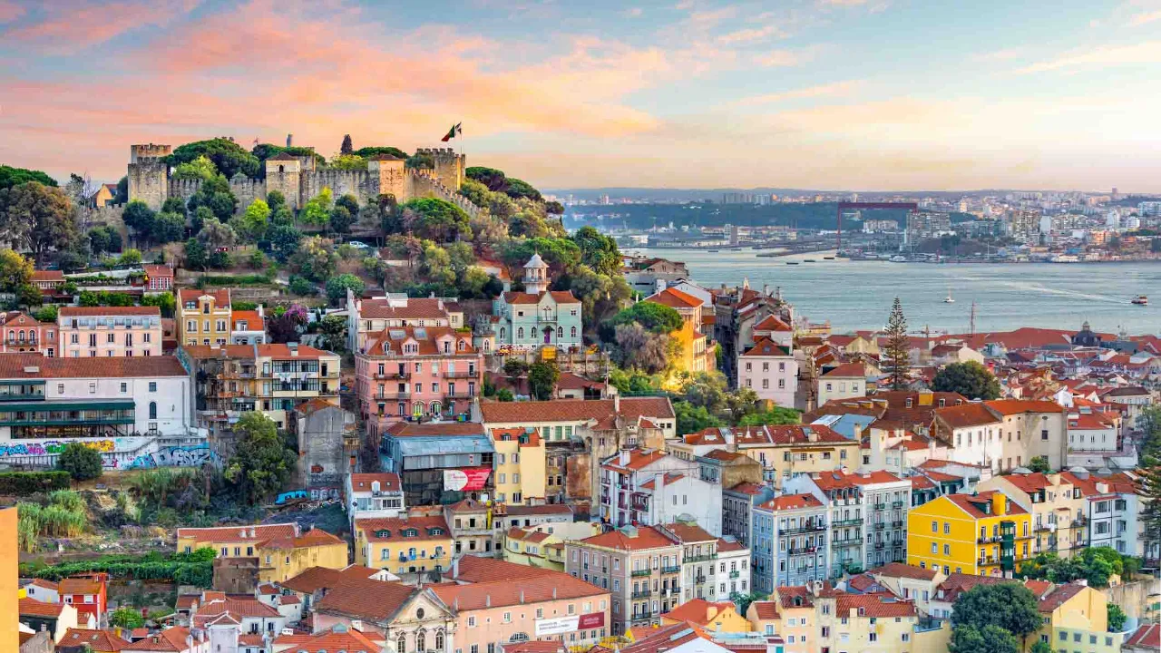Utsikt över Lissabons färgstarka stadsdelar med São Jorge-borgen på toppen och floden Tejo i bakgrunden Utsikt över Lissabons färgstarka stadsdelar med São Jorge-borgen på toppen och floden Tejo i bakgrunden