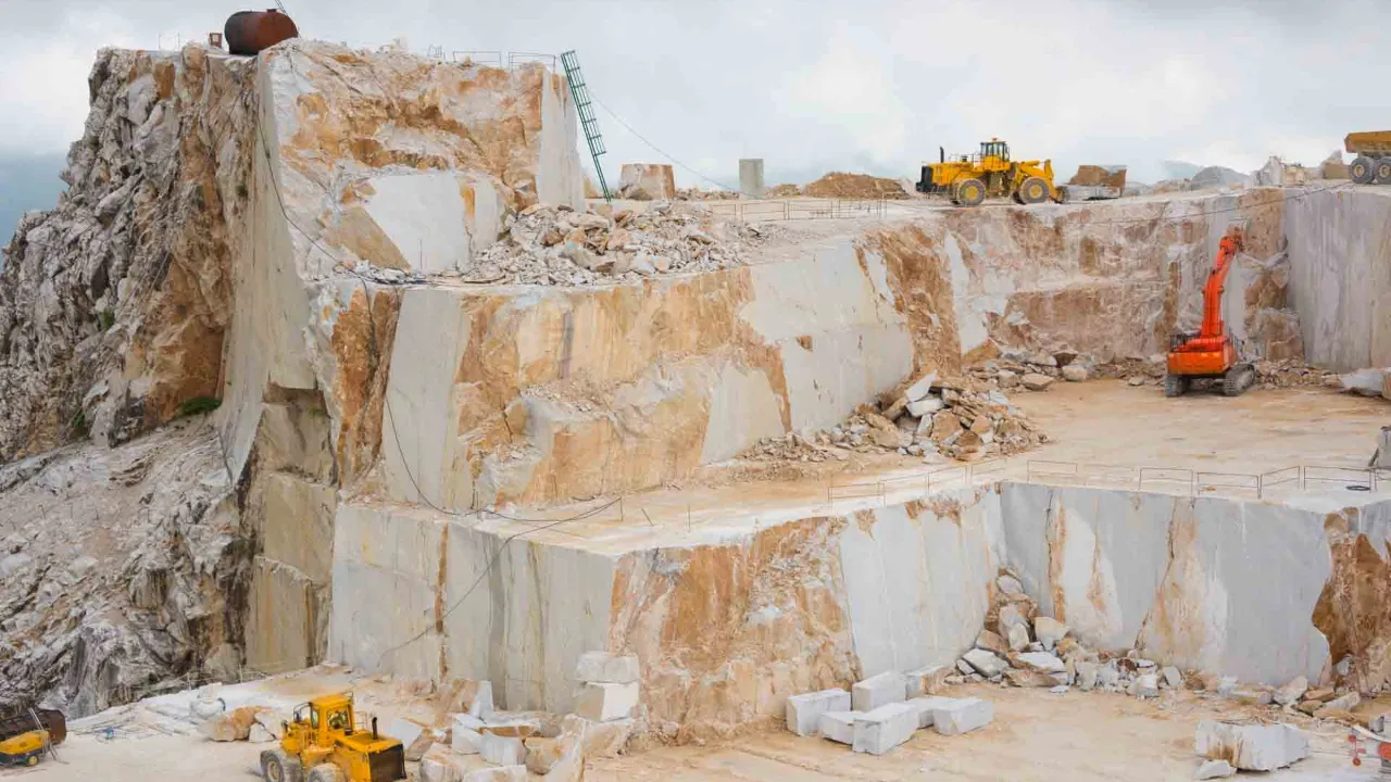 Carrara-marmorbrott med stora stenblock och arbetsmaskiner Carrara-marmorbrott med stora stenblock och arbetsmaskiner