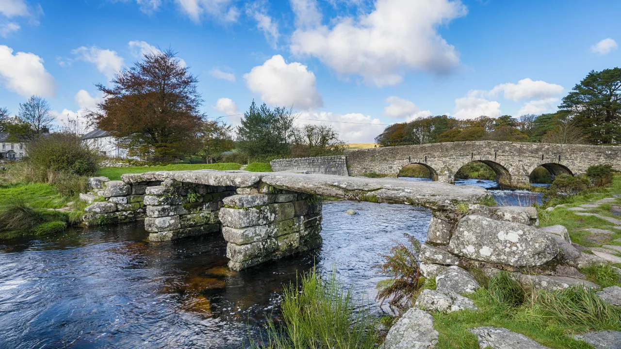 Broarna i Postbridge, Dartmoor – den medeltida Clapper Bridge och den senare stenbron från 1700-talet Broarna i Postbridge, Dartmoor – den medeltida Clapper Bridge och den senare stenbron från 1700-talet